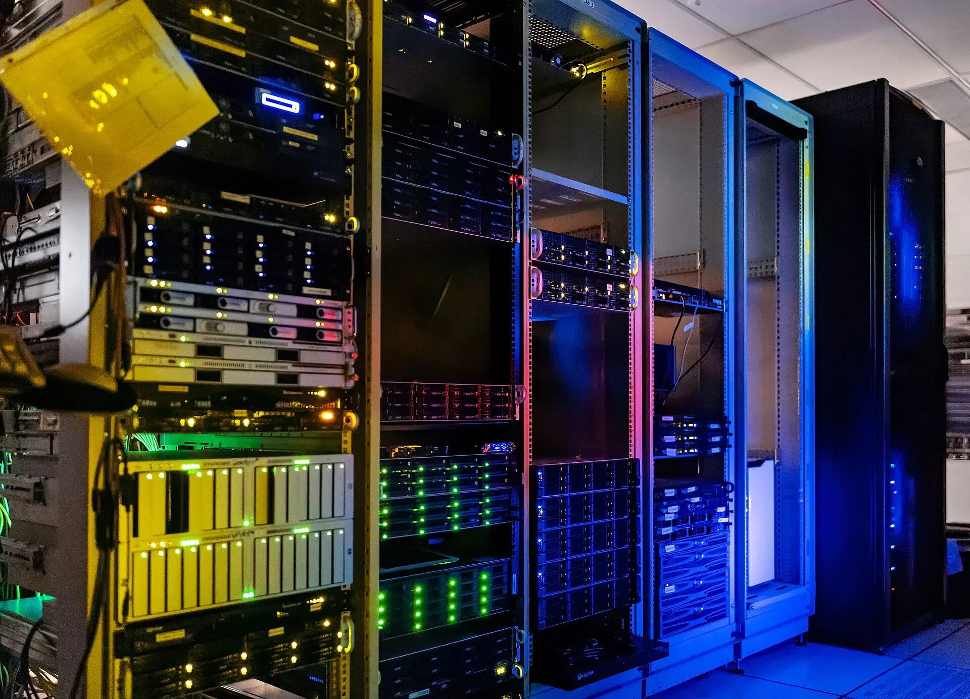Rows of server racks lit with green, red and blue status lights