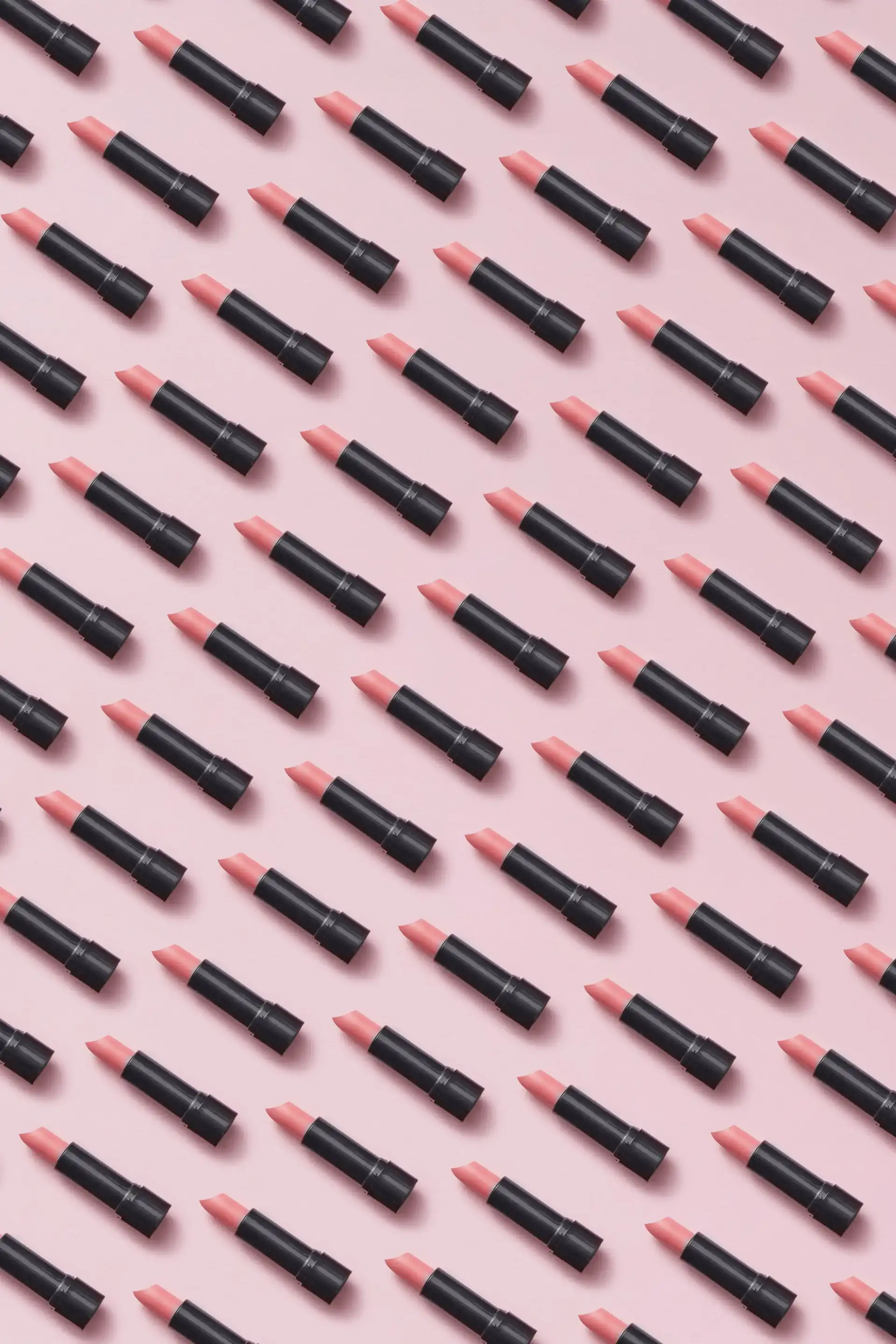 Five unbranded lipsticks in a row, from brick red to pink