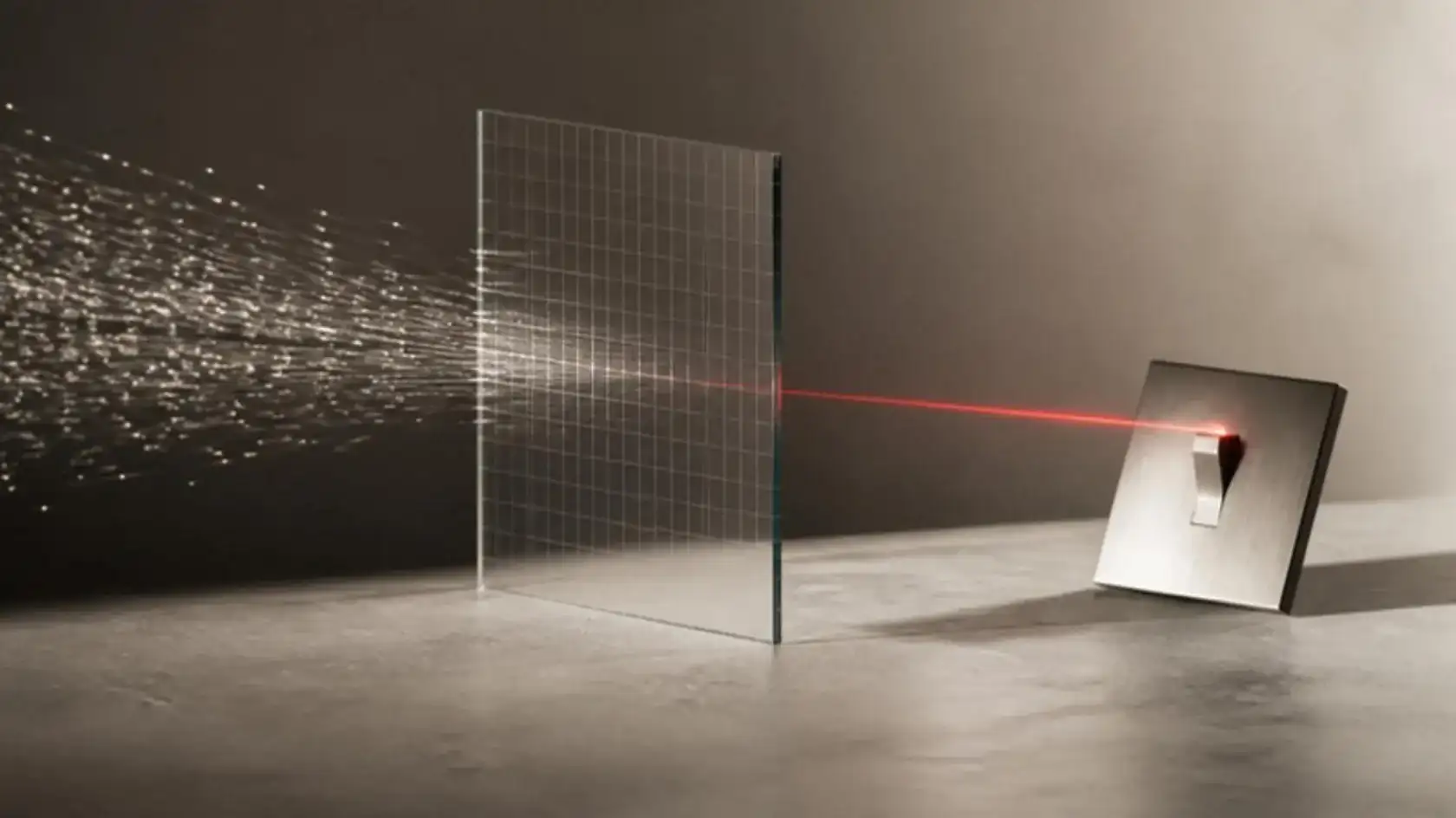 A cloud of fine points of light passing through a glass grid and leaving as one red beam that reaches a steel switch
