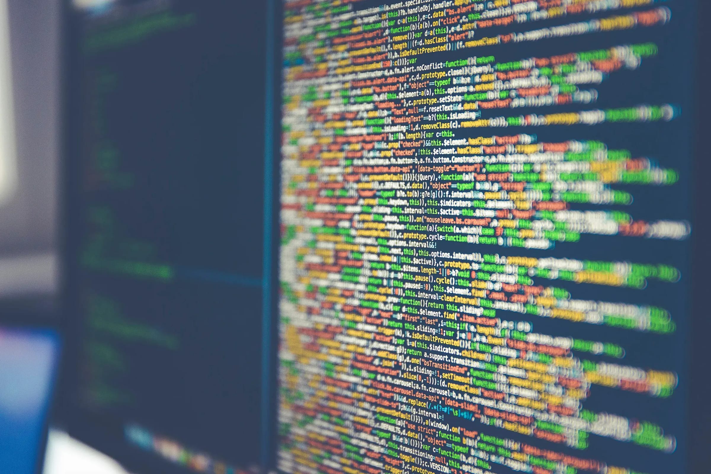 Close-up of colorful program code on a computer monitor, slightly out of focus